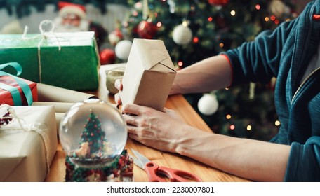 Man wrapping Christmas gift with craft paper. Christmas or New year DIY packing Concept.  - Powered by Shutterstock