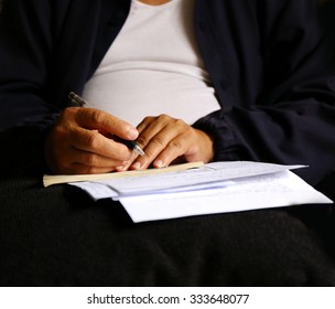  man write pen on document paper ,Close shot of a human hand writing something on the paper on the foreground, think and plan business.