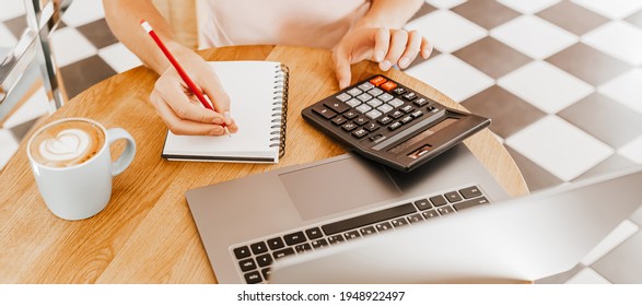 Man Writes Business Information In Notebook At Workplace In Office With Calculator And Laptop