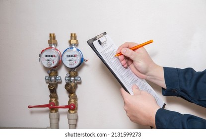 A man writes down the readings of water meters with a pen on paper. The concept of paying for utilities. Rise in price per cubic meter of water, close-up - Shutterstock ID 2131599273