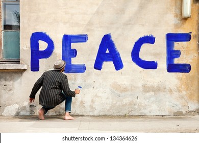 Man Writes On A Wall For The Peace In The World