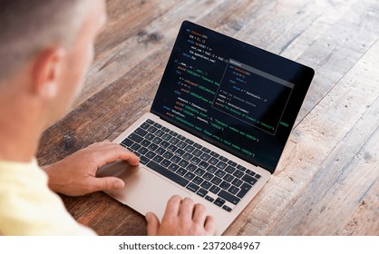 Man writing computer code on laptop
