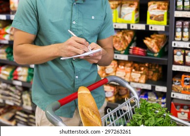 Man writing in his notepad in aisle at supermarket - Powered by Shutterstock