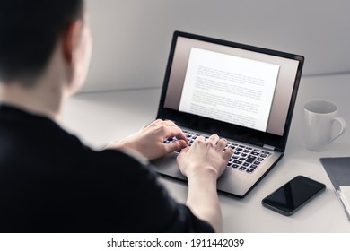 Man writing with laptop. Job applicant making his resume, cv or application. Freelance writer, journalist or teacher working in home office. Workspace with computer and phone. Blogger typing blog.