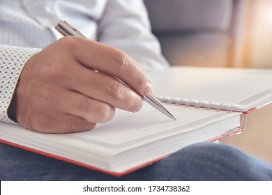 Man writing in a notebook. 