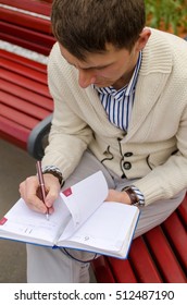 Man is writing at the notebook