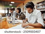 Man, writing and notes in library for education, studying and headphones for music. Student, study group and research at laptop for knowledge, learning and exam preparation on university campus