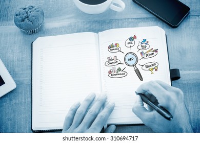 Man writing notes on diary against seo doodle