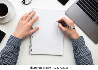 Man writing on notebook in the office. The view from the top. - Powered by Shutterstock