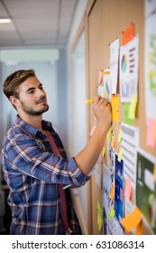 Man Writing On The Sticky Note On The Board In Office