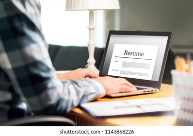 Man writing resume and CV in home office with laptop. Applicant searching for new work and typing curriculum vitae for application. Job seeking, hunt and unemployment. Mock up text in computer screen. - Shutterstock ID 1143868226