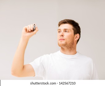 man writing something in the air with marker - Powered by Shutterstock