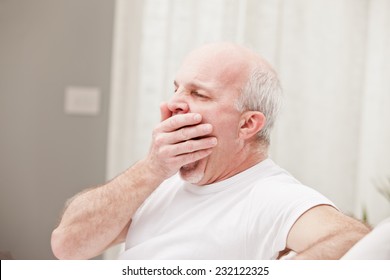 man yawning and going asleep in his white living room - Powered by Shutterstock