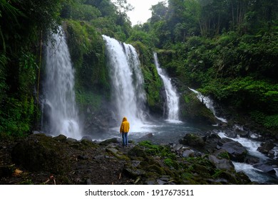 A Man In A Yellow Jacket Enjoying The Beauty Of “Jenggala” Waterfall