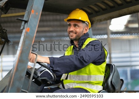 man in a yellow safety vest is driving a forklift. He is smiling and he is enjoying his job