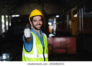 A man in a yellow vest is giving a thumbs up. He is wearing a hard hat and safety vest - Powered by Shutterstock