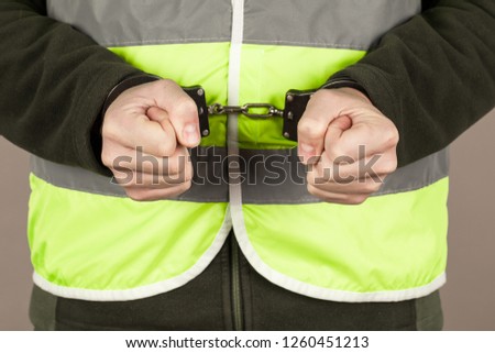man in the yellow vest is handcuffed