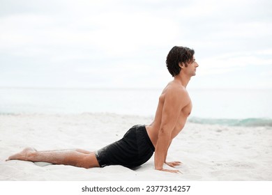 Man, yoga and stretch on beach sand for relax summer, zen or sunshine exercise for health. Male person, cobra pose and muscle for holistic sea practice, spiritual balance or calm ocean mockup - Powered by Shutterstock