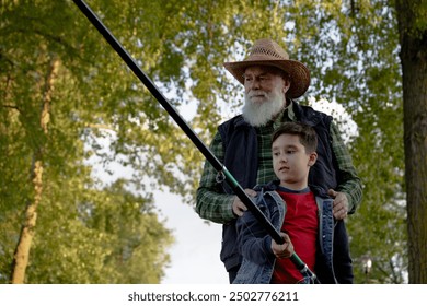 A man and a young boy are enjoying fishing together in the woods - Powered by Shutterstock