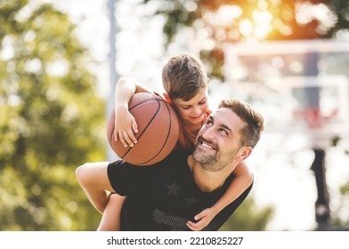 A man and young boy playing basketball on a court, teaching little player and spending time outdoors - Powered by Shutterstock