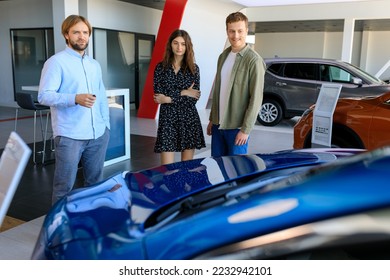 A man and a young woman while choosing a new car. The car dealership manager helps in choosing - Shutterstock ID 2232942101