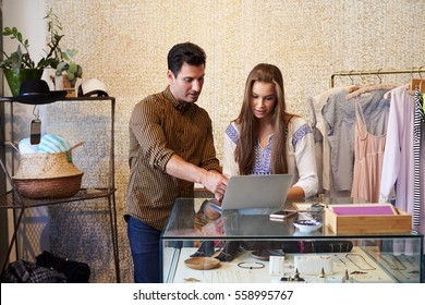 Man And Young Woman Working Together In Clothes Shop