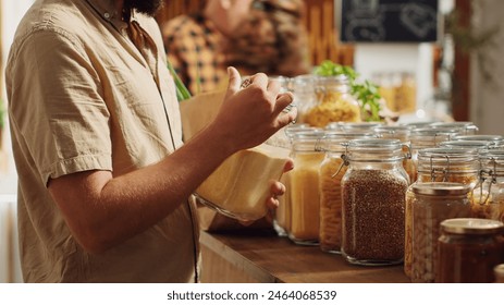 Man in zero waste supermarket thoroughly checking products before making purchase decision, making sure they are natural. Customer verifying pantry staples displayed in local store are organic - Powered by Shutterstock