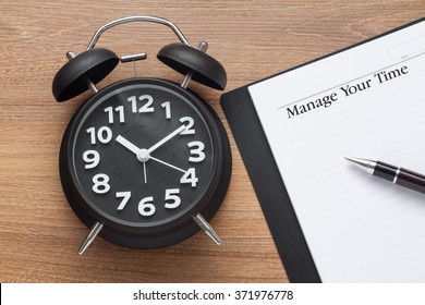 Manage Your Time Conceptual,book,pen And Clock On Wood