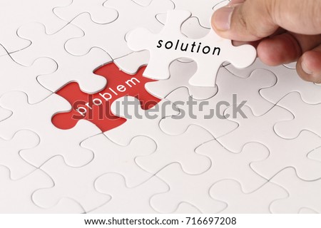 Management concept with hand holding piece of jigsaw puzzle with problem and solution wording