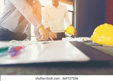 Management Consulting With Engineers Working At Construction Site And Holding Blueprint In His Hand For Management Business Plan.