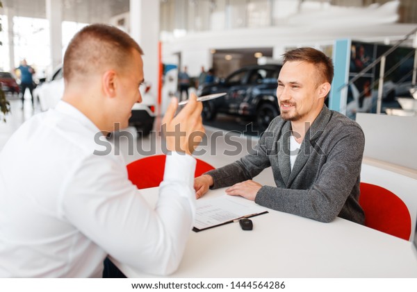 Manager and\
buyer make out the purchase of new\
car