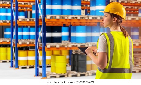 manager is counting chemical barrels. Metal barrels in front of warehouse worker. Manager in yellow uniform. Blurred racks in background. Work in chemical industry. Warehouse worker with tablet - Shutterstock ID 2061075962