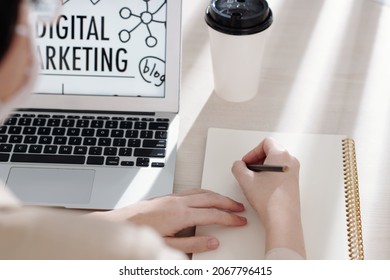 Manager Of Digital Marketing Department Taking Notes In Planner When Working On Laptop Or Watching Presentation Online