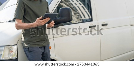 Manager with a digital tablet next to delivery van. Fleet management	