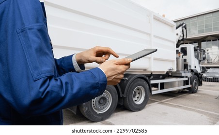 Manager with a digital tablet next to garbage truck. - Powered by Shutterstock