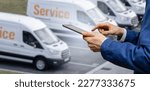 Manager with a digital tablet on the background of vans. Fleet management