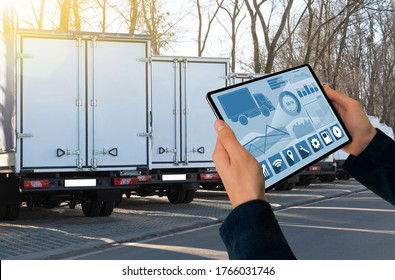 Manager With A Digital Tablet On The Background Of Trucks. Fleet Management