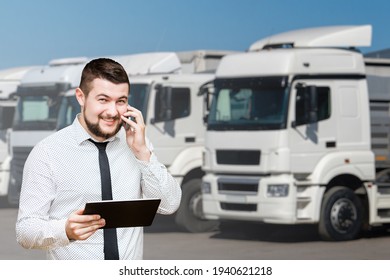 Manager With A Digital Tablet On The Background Of Trucks. Fleet Management