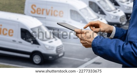 Manager with a digital tablet on the background of vans. Fleet management