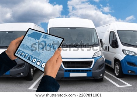 Manager with a digital tablet on the background of vans. Fleet management