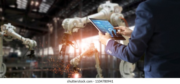
Manager engineer check   control automation robot arms machine in intelligent factory industrial real time monitoring system software  Welding robotics   digital manufacturing operation  