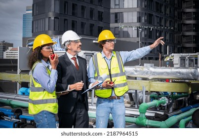 Manager and engineer project looking document file checking building cooling tower air conditioner ,They check work progress chiller HVAC of large industrial building to control air system concept.
