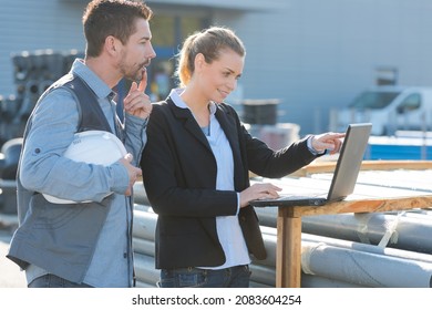 Manager And Engineer Using Laptop At Factory Site