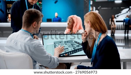 Manager Explains BIM Software Features To Interested Team At Busy Expo Booth