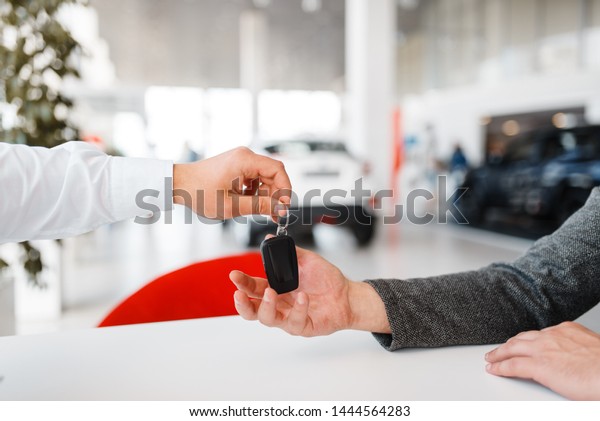 Manager gives
woman key to the new car in
showroom