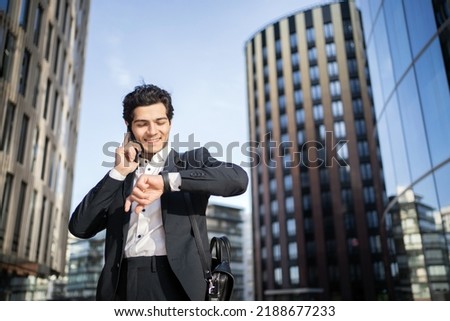 The manager in glasses is a man talking on the phone to work in the office in a business suit