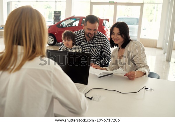 The manager helps the young family choose the\
most comfortable car for the\
city.