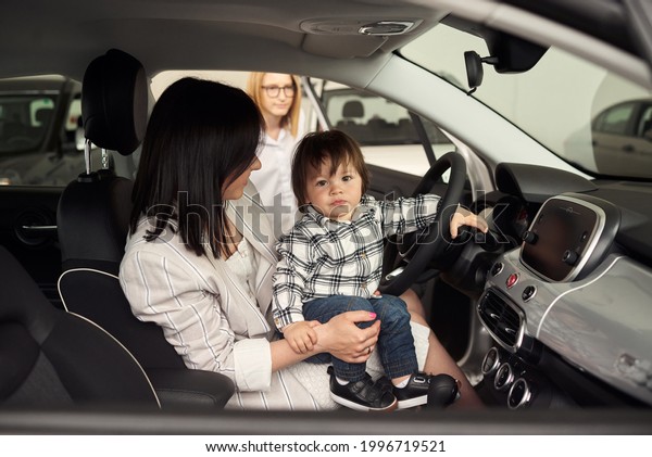 The manager helps the young family choose the\
most comfortable car for the\
city.