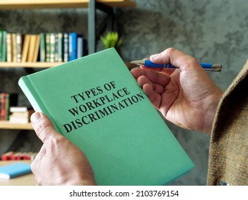 Manager Holds Book Types Of Workplace Discrimination.