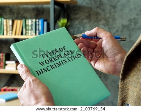 Manager holds book types of workplace discrimination.